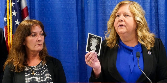Darlene Altman, left, looks on as Nassau County District Attorney Anne Donnelly, right, holds a photo of her mother Diane Cusick during a news conference, Wednesday, June 22, 2022, in Mineola, N.Y. 