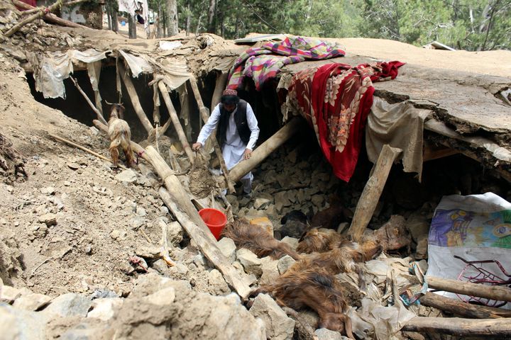 A man collects his belongings from the rubble of his home, which was destroyed in an earthquake that struck part of Khost Province, Afghanistan, on June 22, 2022.