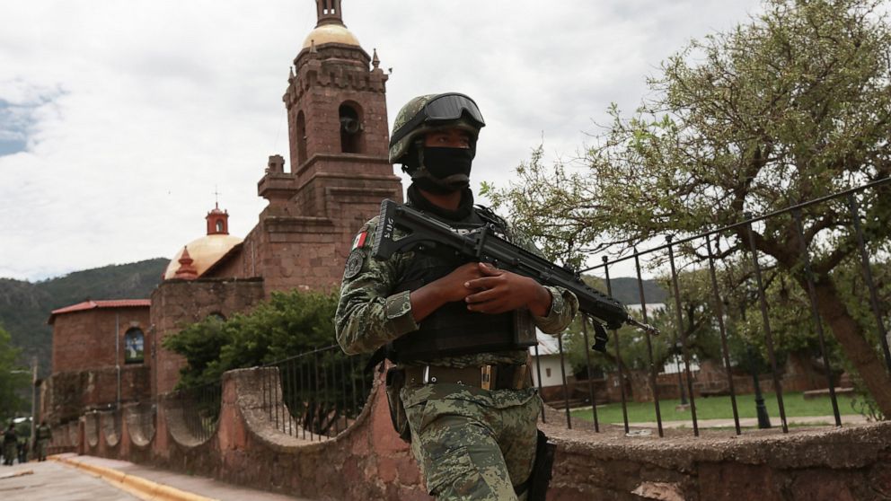 A Mexican soldier patrols outside the Church in Cerocahui, Mexico, Wednesday, June 22, 2022. Two elderly Jesuit priests were killed inside the church where a man pursued by gunmen apparently sought refuge, the religious order´s Mexican branch announc