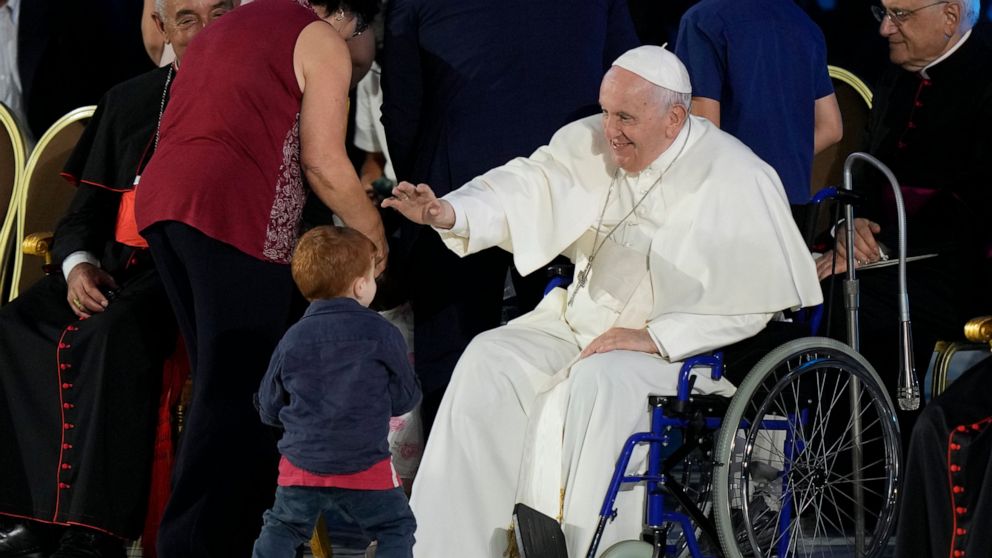 Pope Francis reaches out to a young boy as he attends the Festival of Families in the Paul VI Hall at the Vatican, on the first day of the World Meeting of Families, Wednesday, June 22, 2022. (AP Photo/Andrew Medichini)