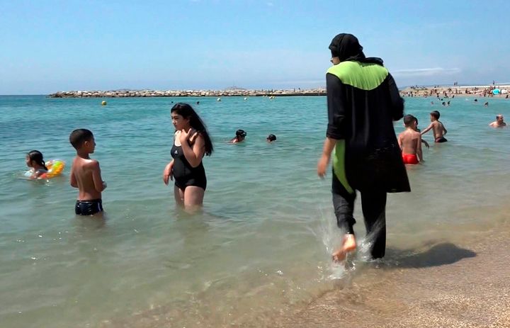 A woman wearing a burkini walks into the sea on the coast of Marseille in a file photo.