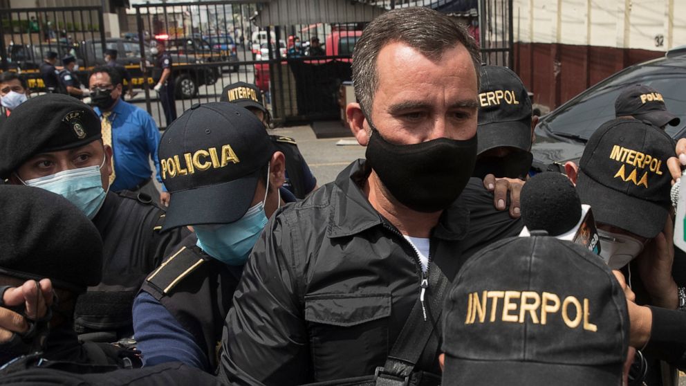 FILE - Former communications minister Alejandro Sinibaldi is escorted by police to a courtroom after surrendering to the authorities, in Guatemala City, Aug. 24, 2020. A Guatemalan court tossed out an agreement that made it easier to prosecute briber