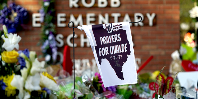 A banner hangs at a memorial outside Robb Elementary School, the site of a May mass shooting that killed 19 students and two teachers, on Friday, June 3.