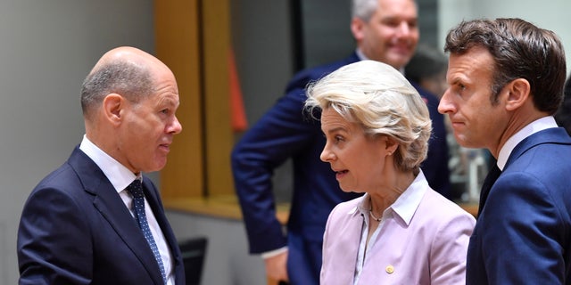 European Commission President Ursula von der Leyen, center, and French President Emmanuel Macron, right, speak with German Chancellor Olaf Scholz during a round table meeting at an EU summit in Brussels, Thursday, June 23, 2022. European Union leaders are expected to approve Thursday a proposal to grant Ukraine a EU candidate status, a first step on the long toward membership. The stalled enlargement process to include Western Balkans countries in the bloc is also on their agenda at the summit in Brussels. (AP Photo/Geert Vanden Wijngaert)