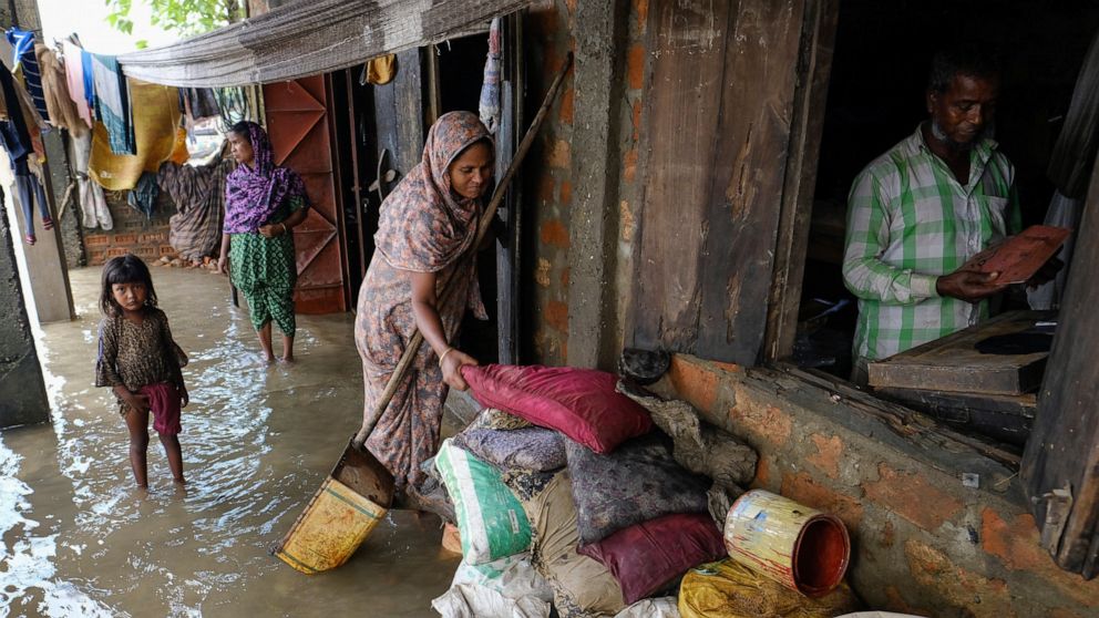 People inspect the damaged belongings in their homes as flood water levels recede slowly in Sylhet, Bangladesh, Wednesday, June 22, 2022. (AP Photo/Mahmud Hossain Opu)
