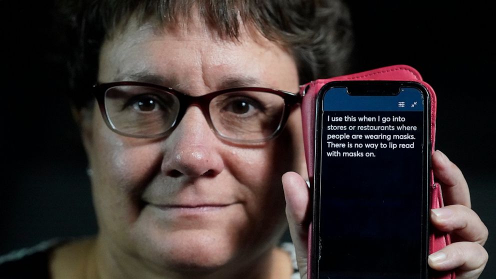 Chelle Wyatt uses her cell phone with the Otter app Friday, April 15, 2022, in Salt Lake City. People with hearing loss have adopted technology to navigate the world, especially as hearing aids are expensive and inaccessible to many. (AP Photo/Rick B