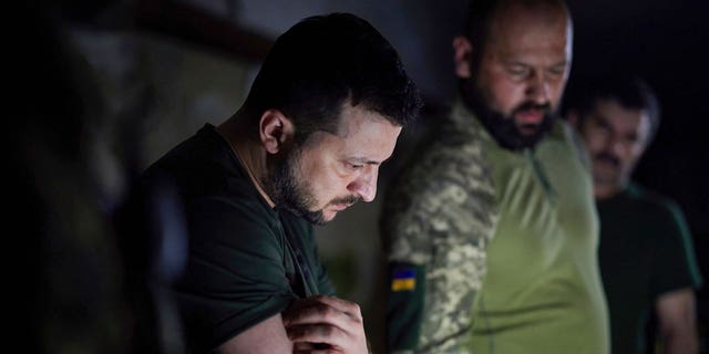 In this photo provided by the Ukrainian Presidential Press Office, Ukrainian President Volodymyr Zelenskyy, left, listens to a servicemen report close to the front line in Donetsk region, Ukraine, Sunday, June 5, 2022. (Ukrainian Presidential Press Office via AP, File)
