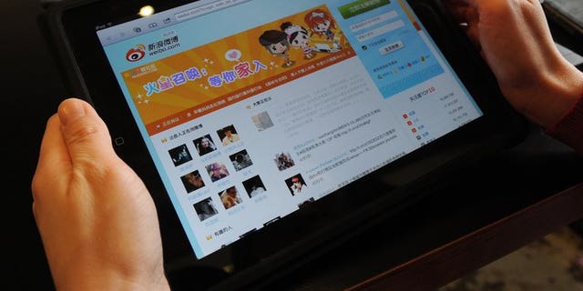 A woman views the Chinese social media website Weibo at a café in Beijing on April 2, 2012.
