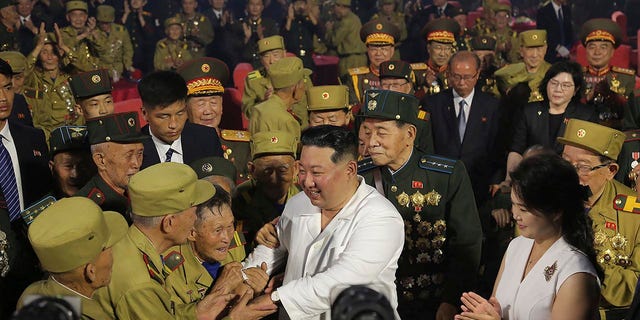 North Korean leader Kim Jong Un, center front, shakes hands with war veterans during a ceremony to mark the 69th anniversary of the end of fighting in the Korean War on July 27, 2022. 