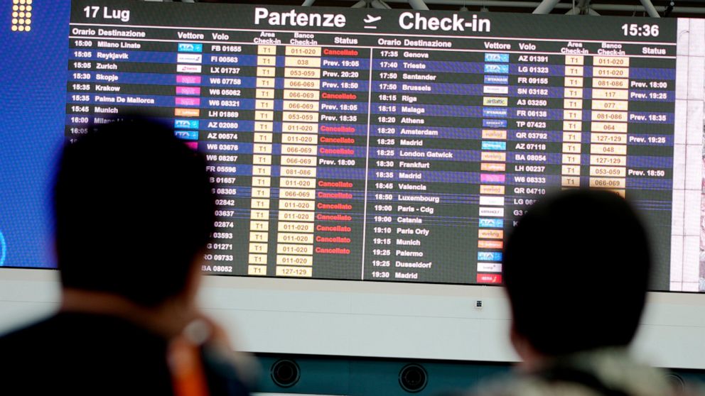 Passengers look at flights timetables in Rome's Leonardo Da Vinci international airport, Sunday, July 17, 2022. Several hundred flights were canceled in Italy Sunday, a peak vacation travel day, because of four-hour walkouts involving employees of lo