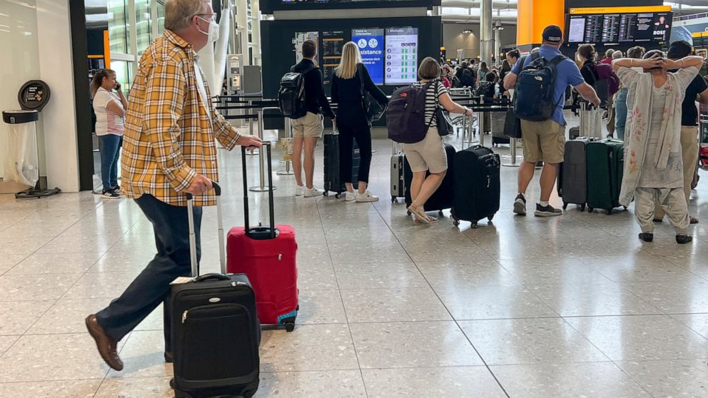 Travellers at Heathrow airport, in London, Wednesday, July 13, 2022. Heathrow Airport has introduced a cap on passenger numbers this summer as the aviation sector struggles to cope with demand for travel. No more than 100,000 daily passengers will be