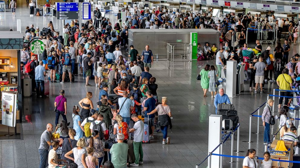 Passengers queue at the check in counters at the airport in Frankfurt, Germany, Monday, July 25, 2022. The Lufthansa ground staff will go for a warning strike next Wednesday. (AP Photo/Michael Probst)