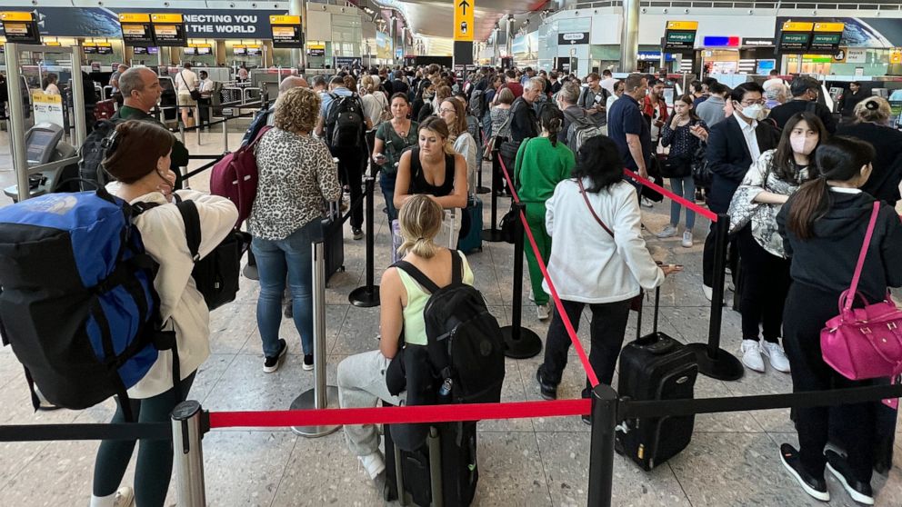 FILE - Travellers queue at security at Heathrow Airport in London, Wednesday, June 22, 2022. London’s Heathrow Airport apologized Monday, July 11, 2022 to passengers whose travels have been disrupted by staff shortages. The airport warned that it may