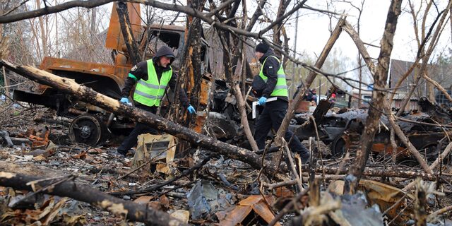 Ukrainian police forensic investigators examine an area with burnt Russian military vehicles destroyed during fighting, in the village of Bervytsia, near Brovary, northeast of Kyiv, on Thursday, April 21.