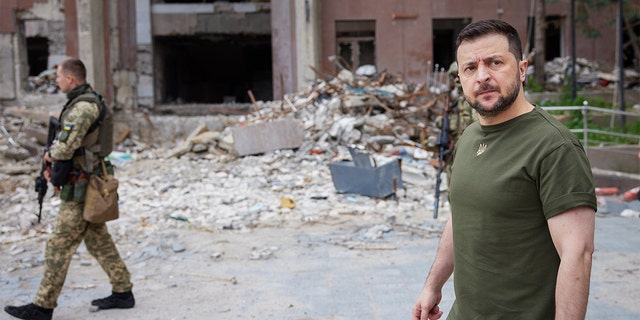 Ukrainian President Volodymyr Zelenskyy inspects damaged buildings as he visits the war-hit Mykolaiv region June 18, 2022. 