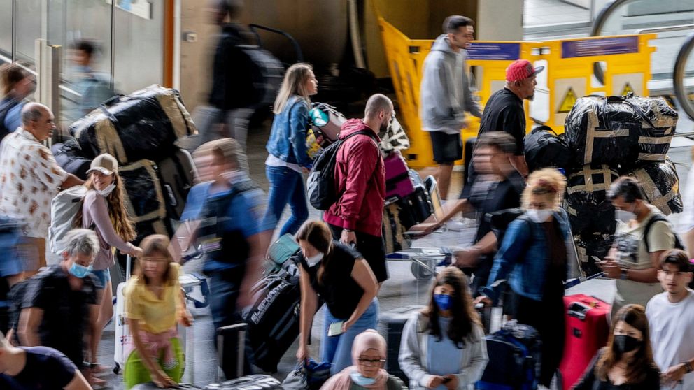 Passengers queue at check in counters at the international airport in Frankfurt, Germany, Wednesday, July 27, 2022. Lufthansa went for a 24-hours-strike on Wednesday, most of the Lufthansa flights had to be cancelled. (AP Photo/Michael Probst)