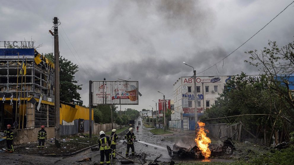 Rescue workers put out the fire of a destroyed car after a Russian attack in a residential neighborhood in downtown Kharkiv, Ukraine, on Monday, July 11, 2022. The top official in the Kharkiv region said Monday the Russian forces launched three missi