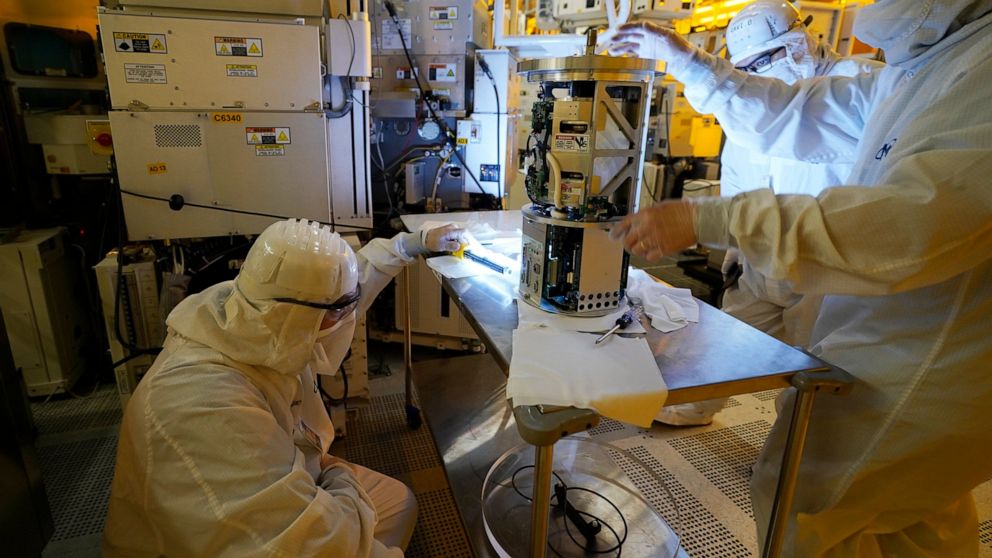 FILE - Technicians inspect a piece of equipment during a tour of the Micron Technology automotive chip manufacturing plant Feb. 11, 2022, in Manassas, Va. A bill to boost semiconductor production in the United States is making its way through the Sen