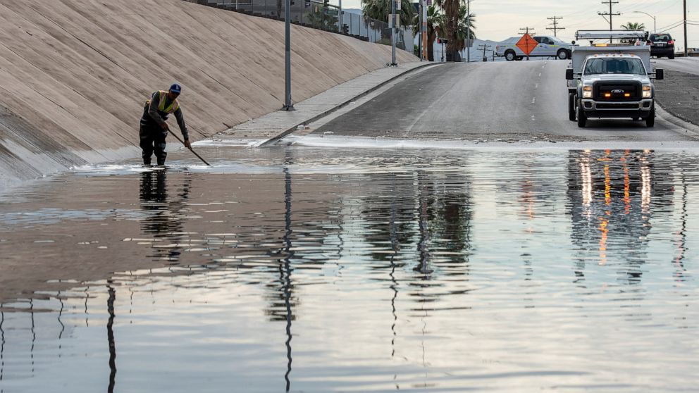 Nevada DOT workers work to clear flood waters from West Washington Ave. near North Main St. on Friday, July 29, 2022, in Las Vegas. (Steel Brooks/Las Vegas Review-Journal via AP)