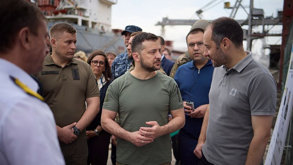 In this photo provided by the Ukrainian Presidential Press Office, Ukrainian President Volodymyr Zelenskyy, center, surrounded by ambassadors of different countries and UN officials, visits a port in Chornomork during loading of grain on a Turkish sh