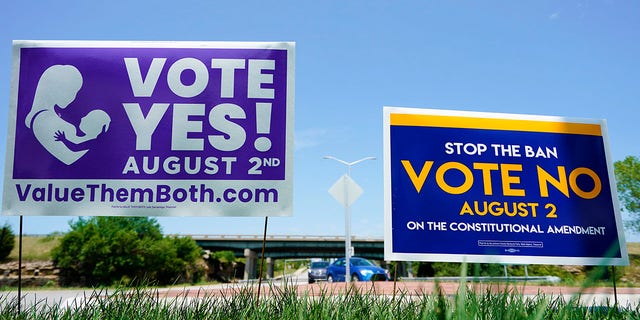 Signs in favor and against the Kansas Constitutional Amendment On Abortion are displayed outside Kansas 10 Highway on Aug. 1, 2022 in Lenexa, Kansas.