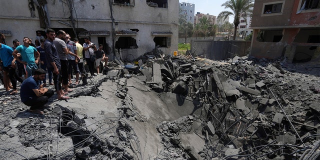 Residents inspect the rubble of destroyed residential building which was hit by Israeli airstrikes, in Gaza, Saturday, Aug. 6, 2022. 
