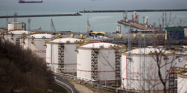 Oil storage tanks stand at the RN-Tuapsinsky refinery, operated by Rosneft Oil Co., as tankers sail beyond in Tuapse, Russia, on Monday, March 23, 2020. Major oil currencies have fallen much more this month following the plunge in Brent crude prices to less than $30 a barrel, with Russias ruble down by 15%. Photographer: Andrey Rudakov/Bloomberg via Getty Images