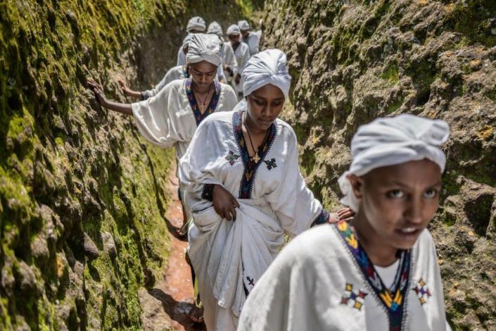 Young women walk through the cave of Saint George during Ashenda festival, at Saint George Church, in Lalibela, Ethiopia.