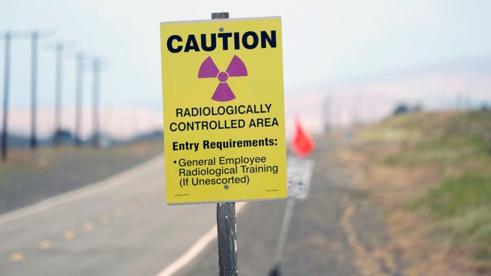 FILE - A caution sign is shown on a road on the Hanford Nuclear Reservation on June 2, 2022. A deal to address two nuclear waste storage tanks that are leaking radioactive materials into the soil on the reservation in Washington state has been reache