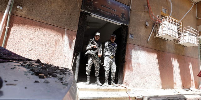 Security members stand at the scene where a deadly fire broke out at the Abu Sifin church in Cairo's Imbaba neighborhood on Sunday.