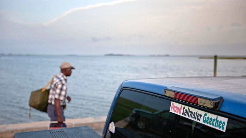 FILE - A sticker celebrating the Geechee heritage is seen on a pickup truck as passengers board a ferry to the mainland on Sapelo Island, Ga., June 9, 2013. An enclave of slave descendants on the Georgia coast have settled a federal lawsuit that clai