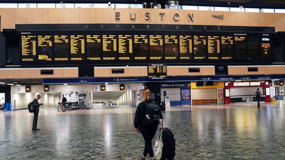 Passengers stand on a deserted London Euston train station, in London, Thursday Aug. 18, 2022. Rail services are set to be severely disrupted as members of the Transport Salaried Staffs Association (TSSA) and the Rail, Maritime and Transport (RMT) un