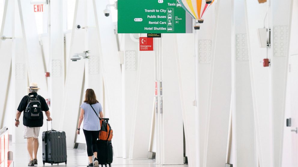 FILE - People walk through John F. Kennedy International Airport on June 28, 2022, in New York. Labor unions are pressuring U.S. airlines not to buy back their own stock and instead to spend the money on hiring more workers and fixing problems that c