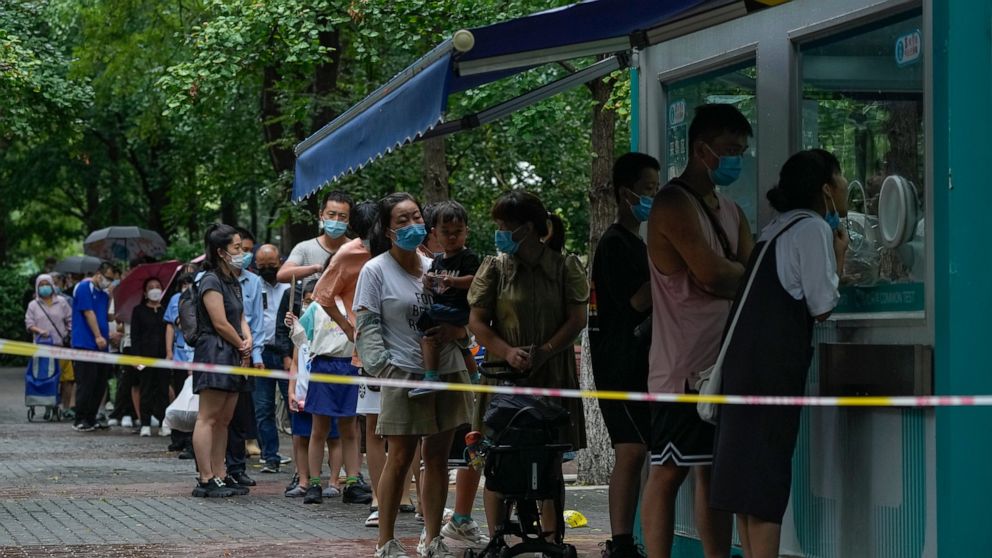 Residents wearing face masks wait in line to get their routine COVID-19 throat swabs at a coronavirus testing site in Beijing, Tuesday, Aug. 9, 2022. Chinese authorities have closed Tibet's famed Potala Palace after a minor outbreak of COVID-19 was r