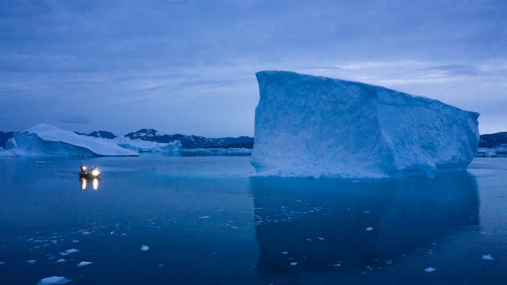 FILE - A boat navigates at night next to large icebergs in eastern Greenland on Aug. 15, 2019. Zombie ice from the massive Greenland ice sheet will eventually raise global sea level by at least 10 inches (27 centimeters) on its own, according to a st