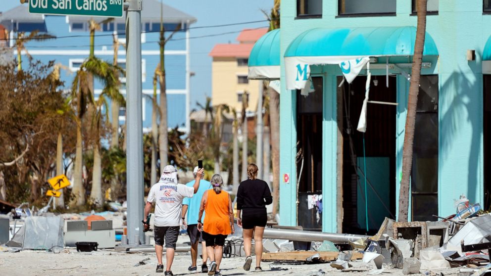 Island residents walk around the downtown area on the island of Fort Myers Beach, Fla., Friday, Sept. 30, 2022. Hurricane Ian made landfall Wednesday, Sept. 28, 2022, as a Category 4 hurricane on the southwest coast of Florida. (Amy Beth Bennett/Sout