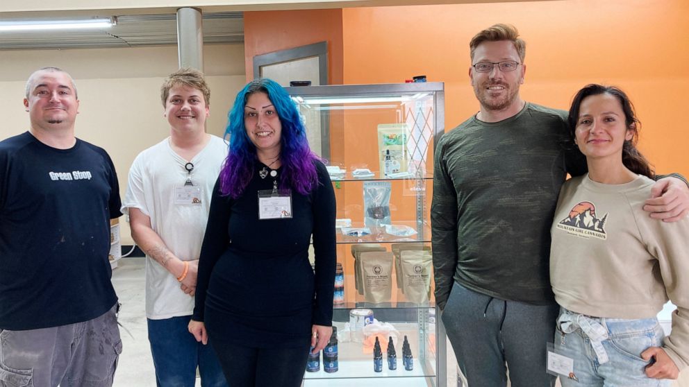 Ana and Josh MacDuff, right, and their employees pose inside their new Mountain Girl Cannabis store, Thursday, Sept. 29, 2022, in Rutland, Vt. Vermont's recreational retail marijuana market opens Saturday, Oct. 1, 2022, with three stores doing busine