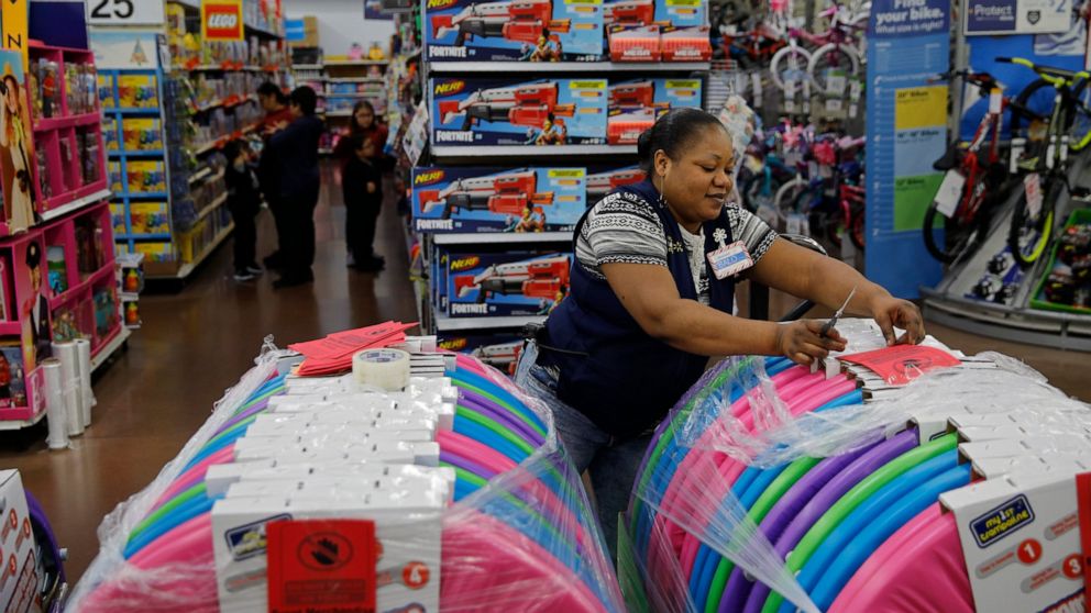 FILE - Balo Balogun labels items in preparation for a holiday sale at a Walmart Supercenter, Wednesday, Nov. 27, 2019, in Las Vegas. Walmart plans to hire 40,000 U.S. workers for the holidays, a majority of them seasonal workers. The move announced W