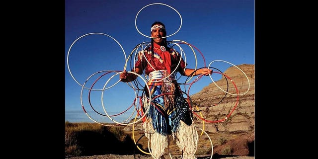 Kevin Locke, an acclaimed Native American flute player, hoop dancer, cultural ambassador and educator, died in South Dakota at age 68 on Sept. 30, 2022, according to his family. Pictured: Kevin Locke performs a hoop dance in the Badlands, South Dakota, in 2002. 
