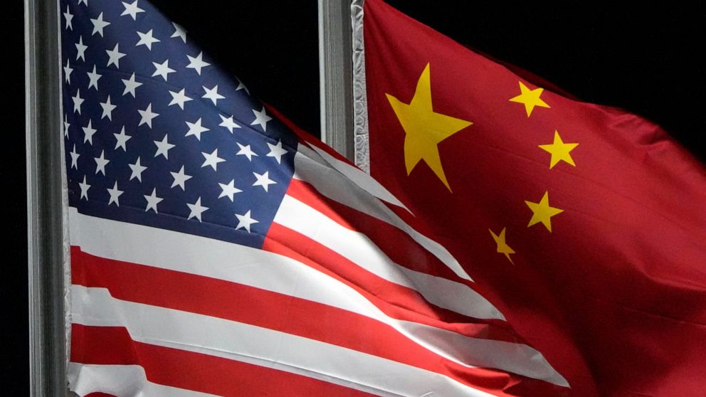 FILE - The American and Chinese flags wave at Genting Snow Park ahead of the 2022 Winter Olympics, Feb. 2, 2022, in Zhangjiakou, China. The Commerce Department is tightening export controls to limit China’s ability to get advanced computing chips, de