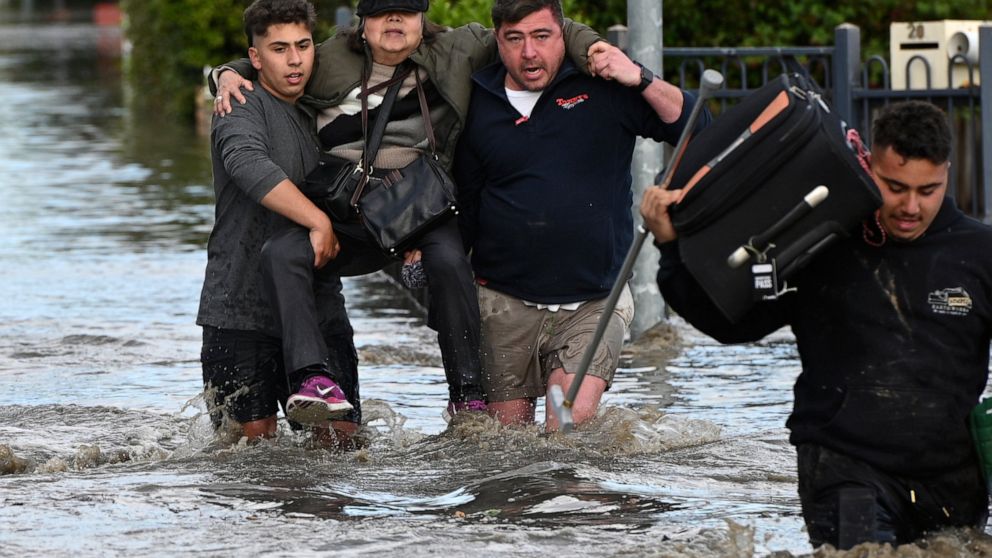 A woman is rescued from floodwater in Melbourne, Australia's suburb of Maribyrnong, Friday, Oct. 14, 2022. Rivers across Australia's most populous states, New South Wales and Victoria, and the island state of Tasmania were rising dangerously with cat