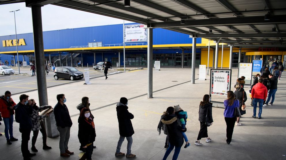 FILE - People wearing protective face mask line up in a queue outside the Swedish furniture giant Ikea shop the last day of the opening of non-essential shops during the coronavirus disease (COVID-19) outbreak, in Aubonne, Switzerland, Saturday, Janu