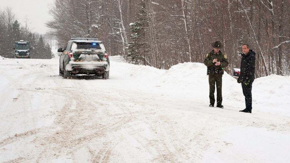 FILE — A Vermont State Trooper, center, speaks to a homeowner, Thursday, Jan. 8, 2018, near an area on Peacham Road, in Barnet, Vt., where the body of Gregory Davis was found. Los Angeles biotech investor Serhat Gumrukcu pleaded not guilty Tuesday, O