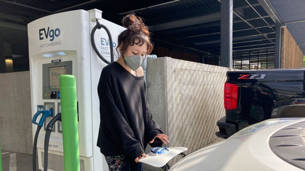 Stephanie Terrell, a Portland, Ore., renter who owns a used electric car, charges it at a public charging station in a grocery store parking lot on Sept. 30, 2022. Terrell bought an EV this fall, but charging it up has been a constant challenge becau