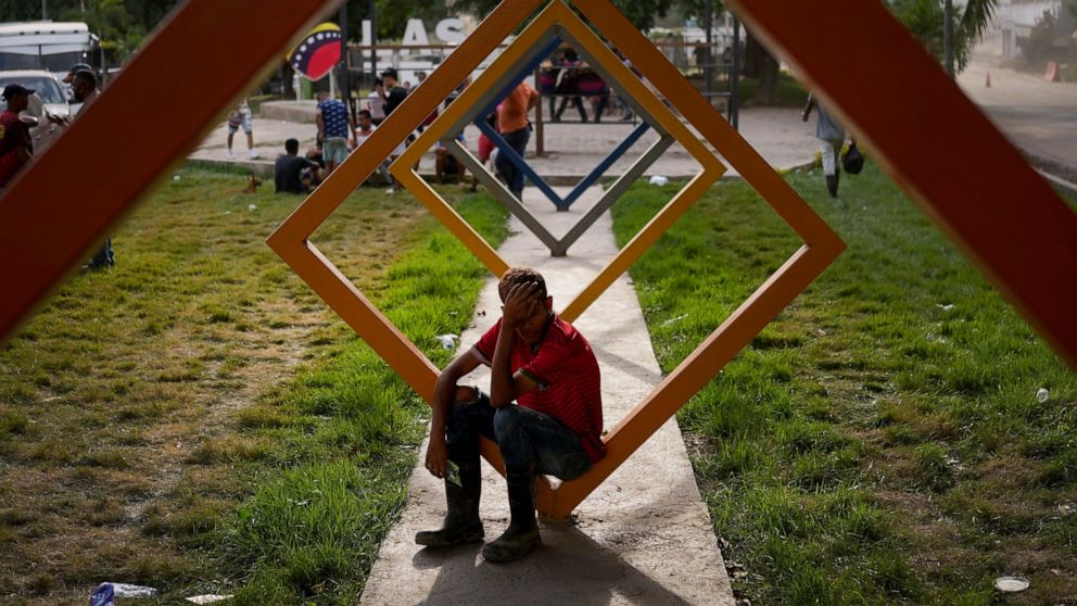 A youth sits in a park in Las Tejerias, Venezuela, Wednesday, Oct. 12, 2022, four days after the town was hit by a landslide caused by heavy rains that killed dozens. (AP Photo/Matias Delacroix)