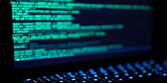 An illustration of a hacker program is seen open on a MacBook Air
