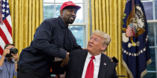 Rapper Kanye West, left, shakes hands with then President Trump during a meeting in the Oval Office of the White House in Washington, D.C., on Thursday, Oct. 11, 2018. 