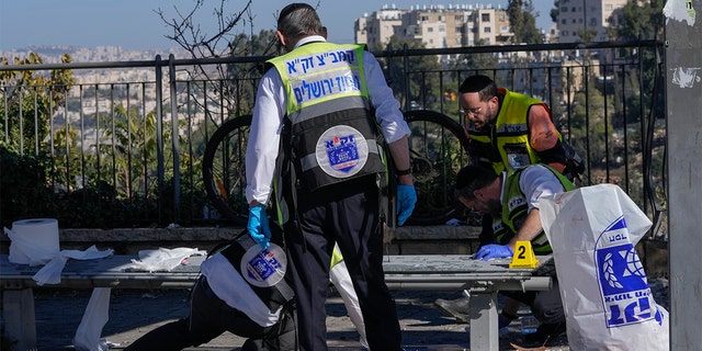 Members of Zaka Rescue and Recovery team clean blood from the scene of an explosion at a bus stop in Jerusalem, Wednesday, Nov. 23, 2022. 
