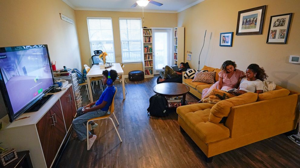 Jessy Correa, second from right, with Genesis Cross, right, Chronicles Cross, back center, and Jerusalem, left, at their apartment Monday, Oct. 24, 2022, in Ocoee, Fla. Correa supports a ballot initiative in Orange County that would limit annual rent