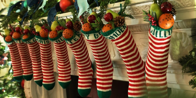 FILE: The traditional Biden family stockings are hung from the fireplace mantel in the State Dining Room of the White House during a press preview of the holiday décor on November 28, 2022 in Washington, DC. 